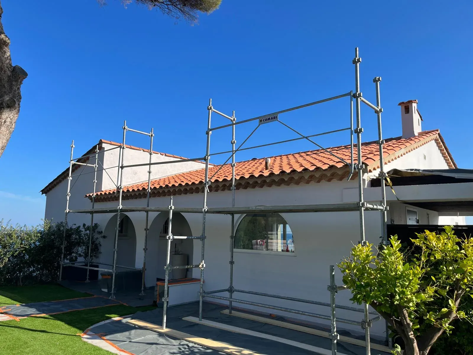Toiture en tuile canal neuve sur une villa méditerranéenne à arcades en bord de mer
