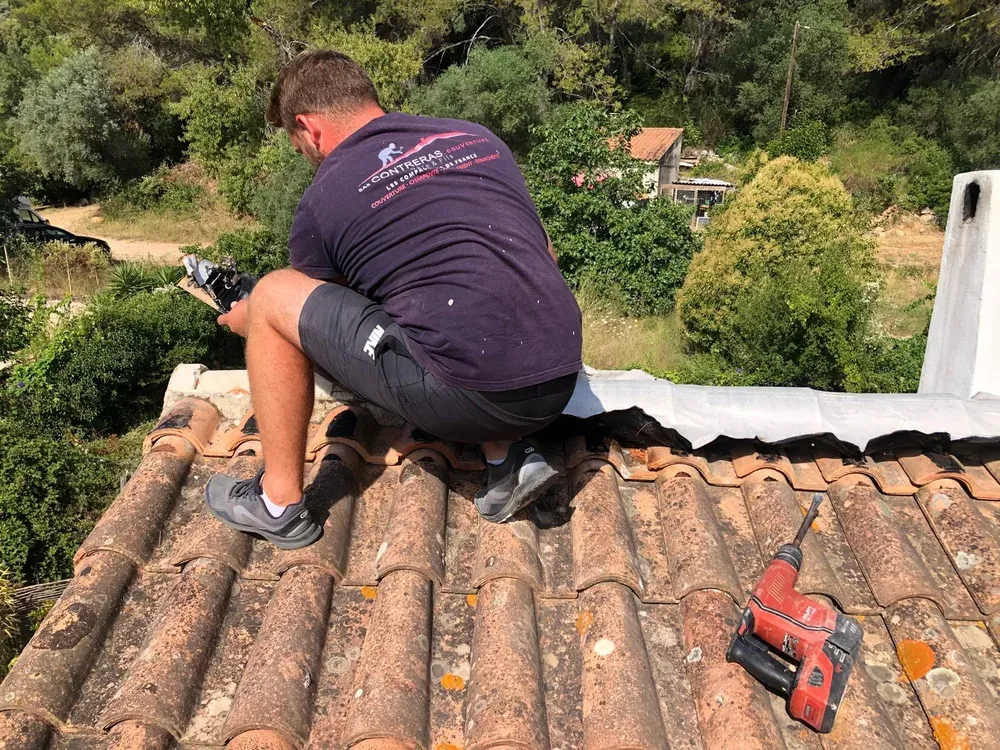 Couvreur de l'entreprise au travail sur une toiture en tuile canal
